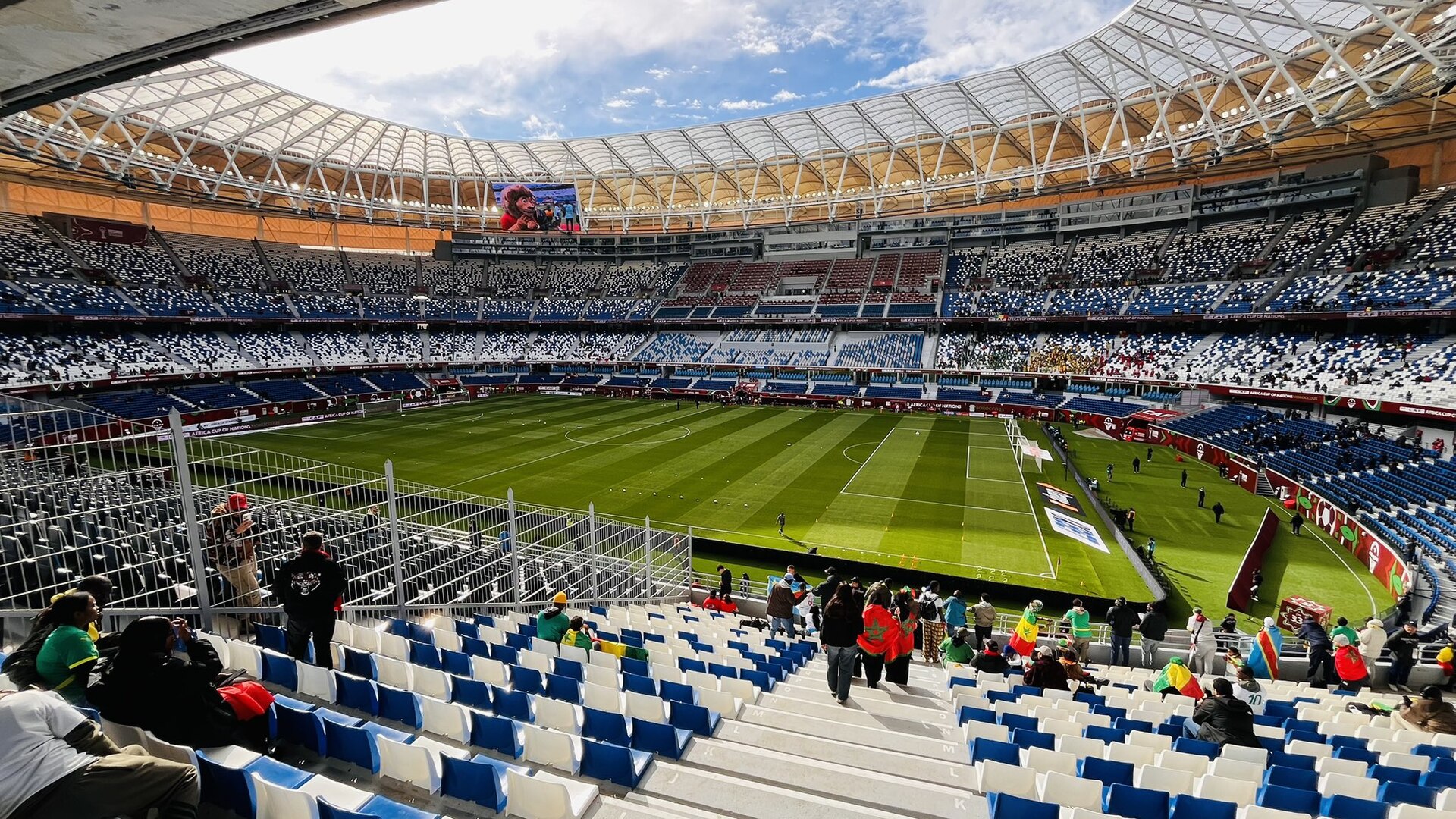 Le Grand Stade de Tanger rénové : tribunes bleues et blanches sous un toit blanc, supporters avant un match de la Coupe d'Afrique